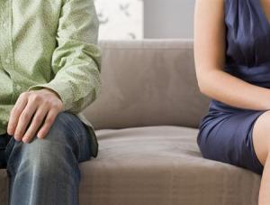 Mid section view of a man and a woman sitting on a couch